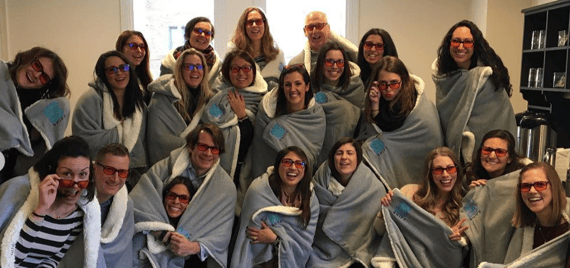 Group photo of employees in cozy blankets